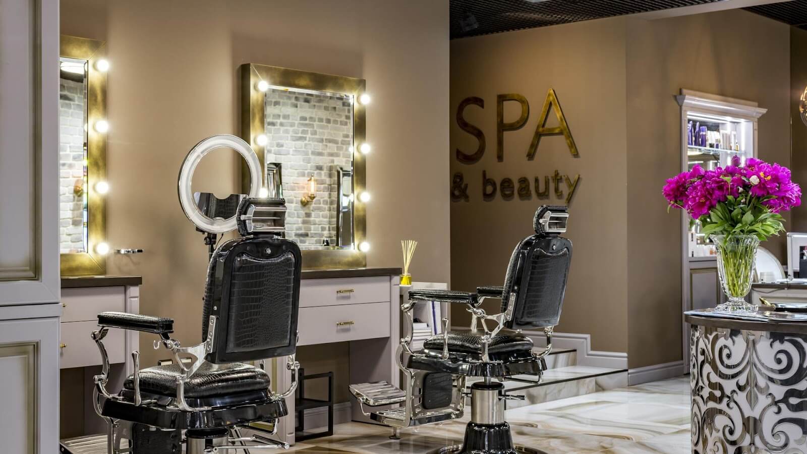 Elegant beauty salon interior featuring vintage barber chairs, illuminated mirrors, and a SPA & beauty sign.